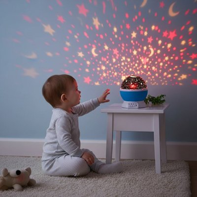 Bébé assis dans une chambre observant les étoiles projetées par un projecteur enfant