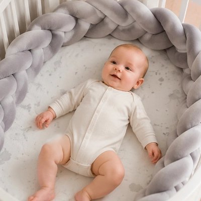 Bébé dormant avec tresse de lit grise 