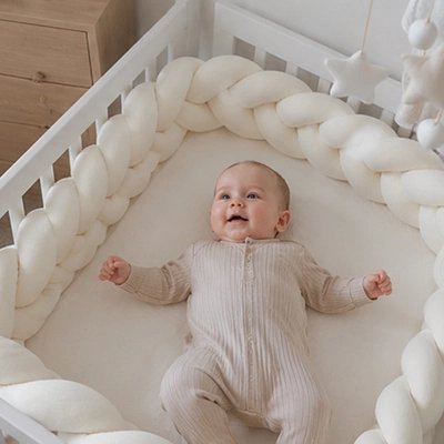 Bébé dormant avec un tour de lit tresse blanc