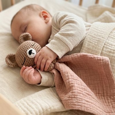 bebe endormi tenant un doudou bebe brique