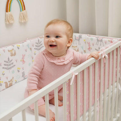 Bébé fille dans un tour de lit bébé