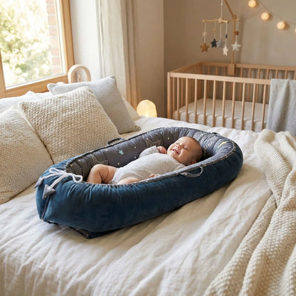 bébé soriant dans un cocon bebe bleu nuit
