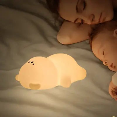bebe veilleuse en forme d’ours en silicone APS diffusant une lumière chaude pendant un moment de tendresse entre une maman et son bébé.
