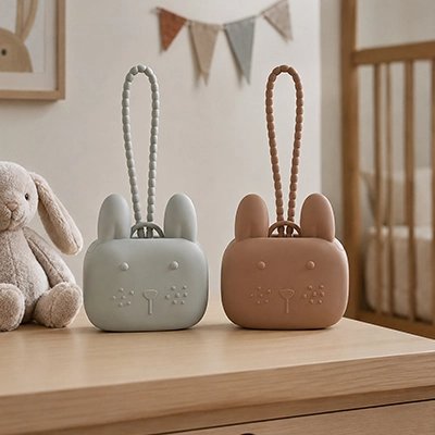 boite pour tetine en silicone de différentes couleurs posées sur une table