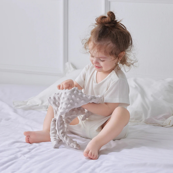 fillette-jouant-avec-doudou-plat-gris