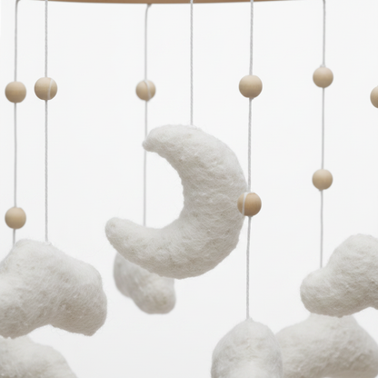 Gros plan sur les détails artisanaux du mobile bébé en feutre et bois naturel