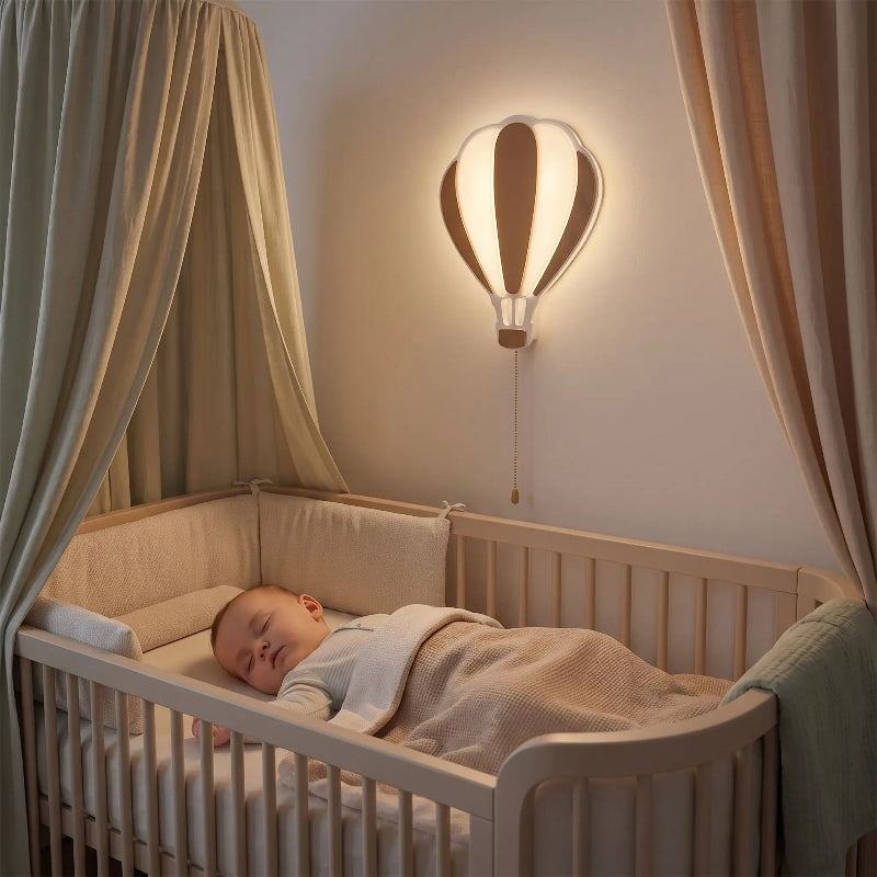 lampe montgolfière allumée au-dessus du lit de bébé