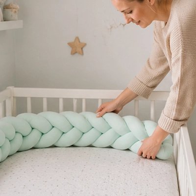 Maman installant une tresse de lit verte