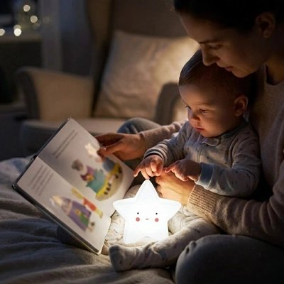 Maman lisant une histoir à son bébé avecun veilleuse bébé