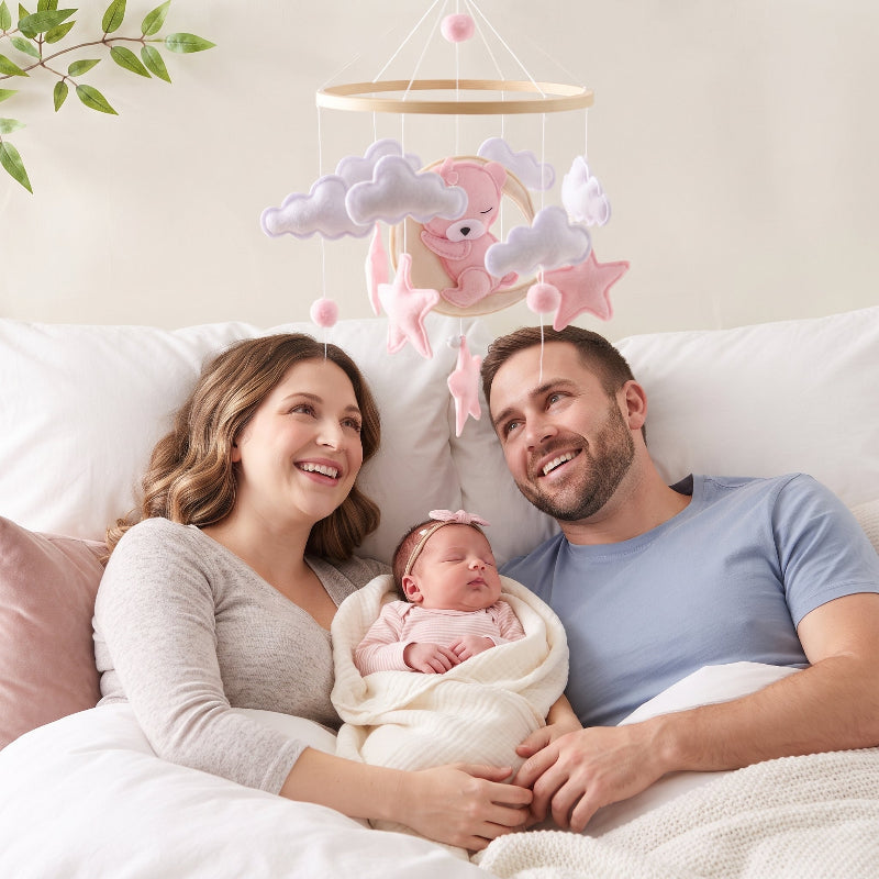 Mobile lit bébé fille ours rose au-dessus des parents et de leur nouveau-né