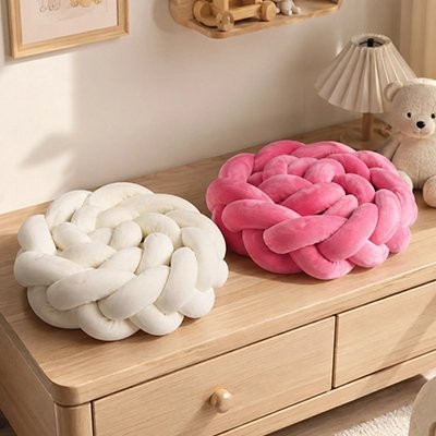 Tour de lit tresse rose et beige sur une commode
