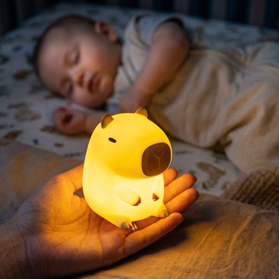 Veilleuse bébé capybara éclairant un bébé qui dort